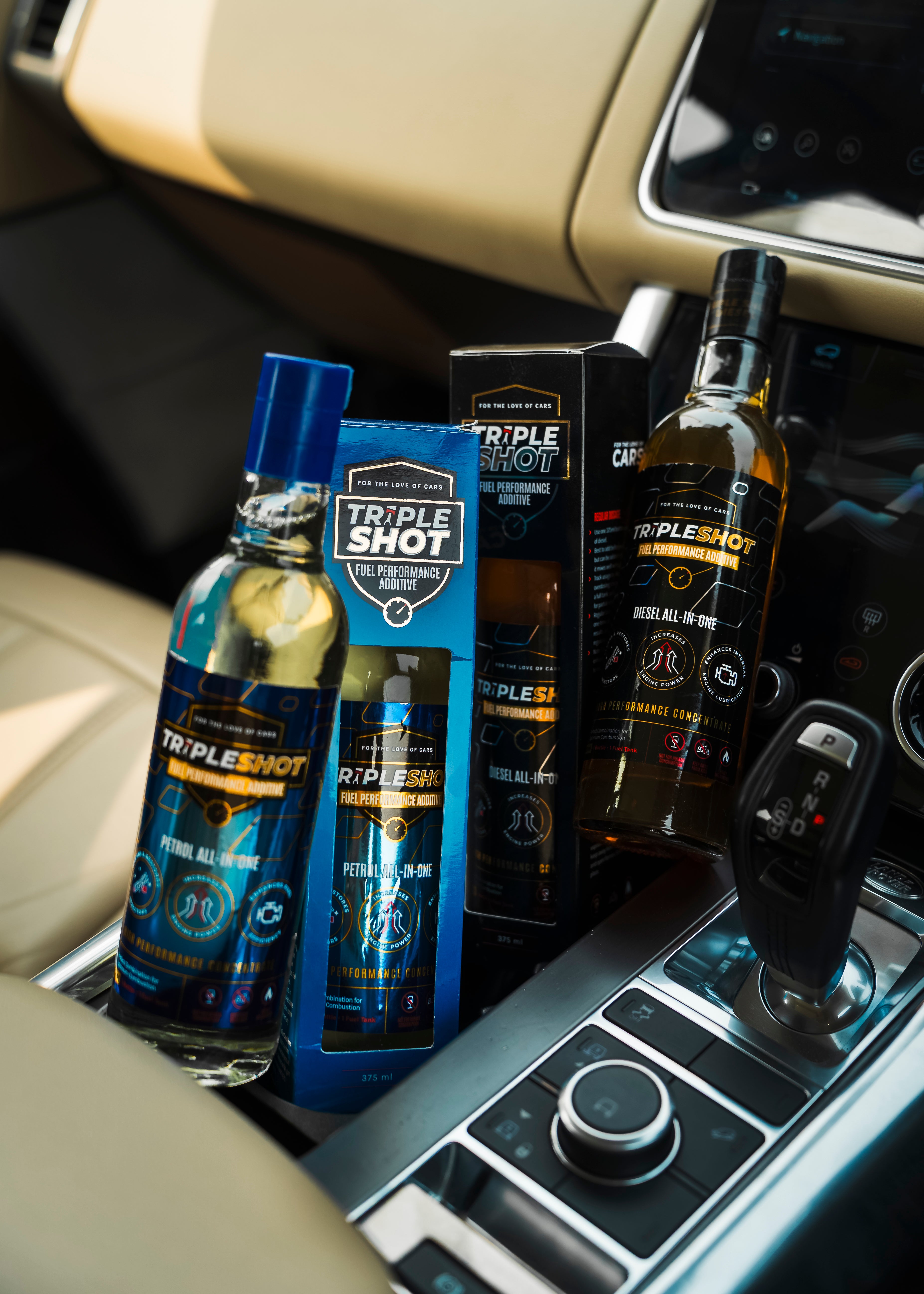 Bottles of Triple Shot fuel additives in a car's cup holder.
