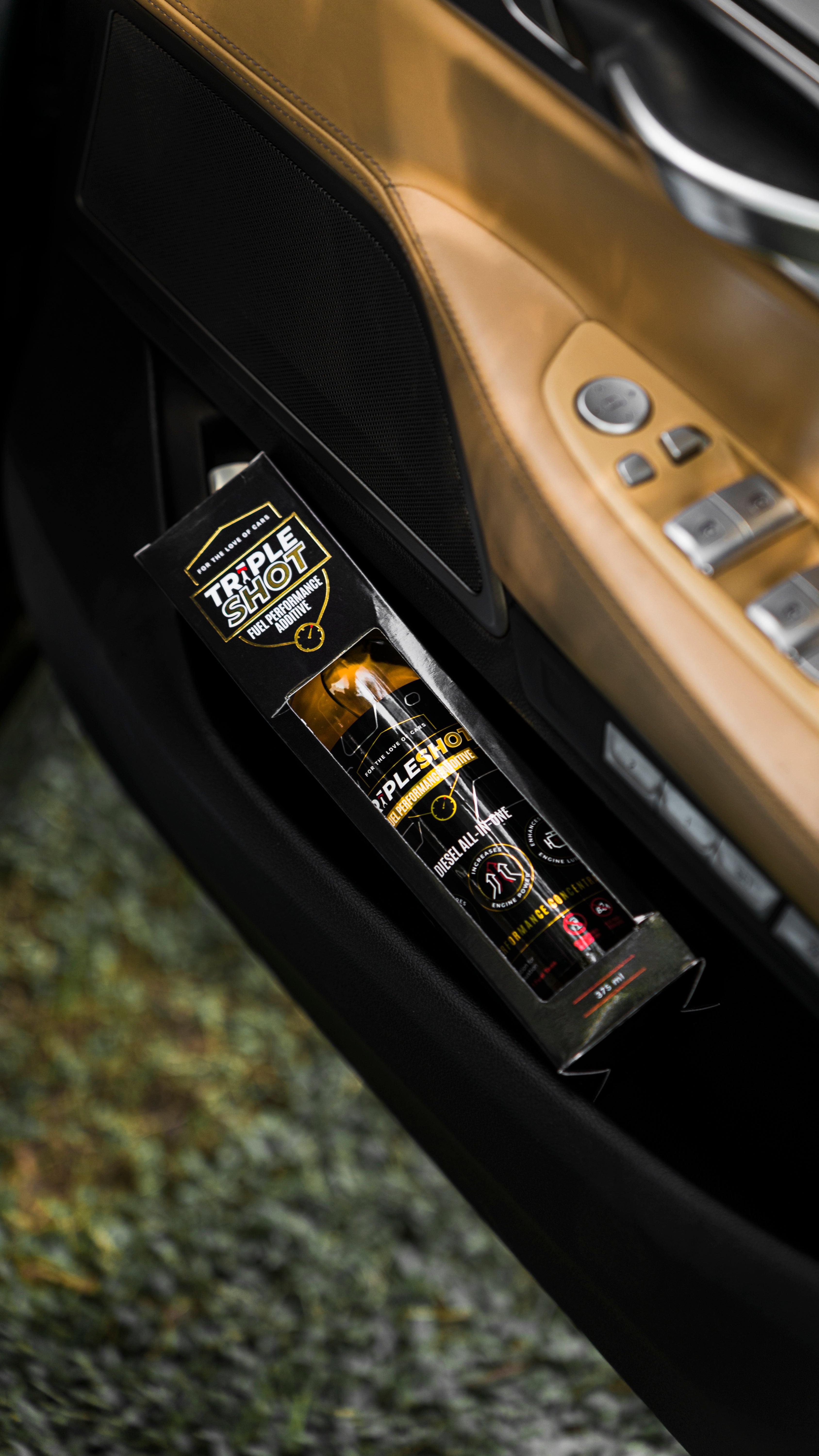 Tripleshot Diesel Fuel Performance Additive box placed inside the door pocket of a car with a tan and black interior. The product packaging is clearly visible, emphasizing its automotive use and portability.